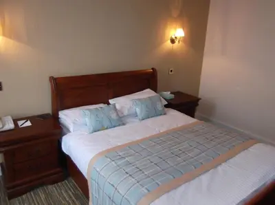 a bedroom with a bed with two nightstands and a bed sidx sidx sidx at Arrochar Hotel 'A Bespoke Hotel' in Arrochar