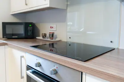 a kitchen with a microwave and a stove top oven at Ground-fl Two Bedroom Apartment in Bridge of Allan in Bridge of Allan