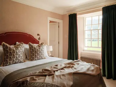 a bedroom with a large bed and a window at The Fortingall in Kenmore