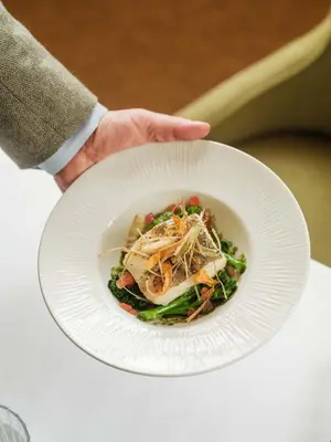 a person holding a white plate with a bowl of food at The Fortingall in Kenmore