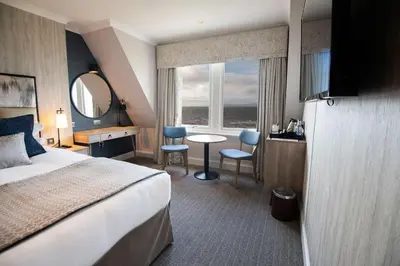 a hotel room with a bed and a desk and a window at Seamill Hydro Hotel in Seamill