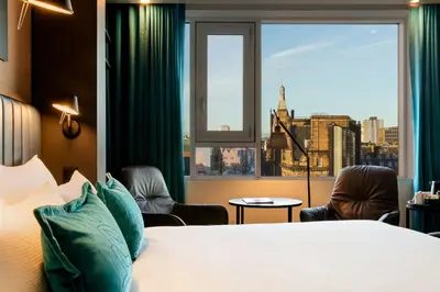 a hotel room with a bed and a large window at Motel One Glasgow in Glasgow