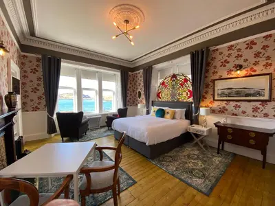 a hotel room with a bed and a living room at Barriemore Oban in Oban