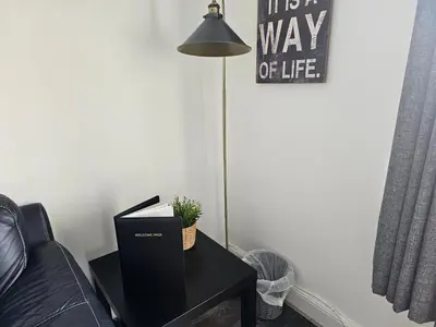 a living room with a black table with a lamp at Snug - Meadhan Apartment in Helensburgh