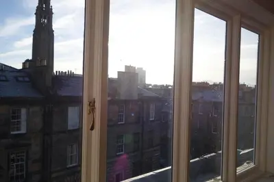 a window view of a city with a clock tower at Sophisticated Edinburgh Apartment in City Centre in Edinburgh