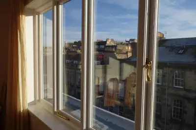 a window with a view of a city at Sophisticated Edinburgh Apartment in City Centre in Edinburgh