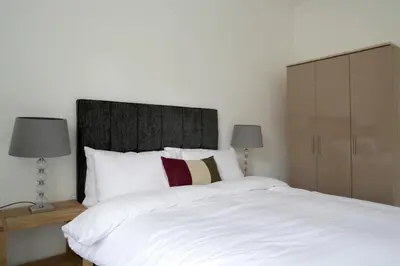 a bedroom with a large white bed with two lamps at Stylish 2 Bedroom Bruntsfield Apartment in Edinburgh in Edinburgh