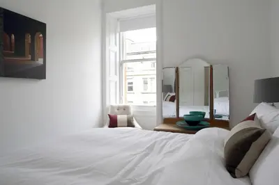 a bedroom with a white bed and a mirror at Stylish 2 Bedroom Bruntsfield Apartment in Edinburgh in Edinburgh
