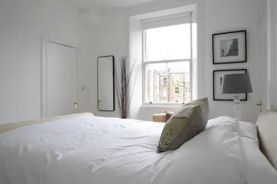 a white bedroom with a bed with a pillow on it at Stylish 2 Bedroom Bruntsfield Apartment in Edinburgh in Edinburgh