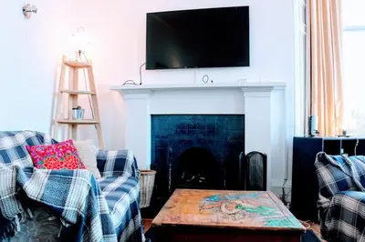 a living room with a fireplace with a tv above it at Traditional Apartment oer the Meadows in Edinburgh