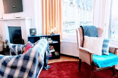 a living room with two chairs and a window at Traditional Apartment oer the Meadows in Edinburgh
