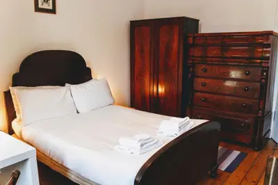 a bedroom with a bed and a dresser at Traditional Apartment oer the Meadows in Edinburgh