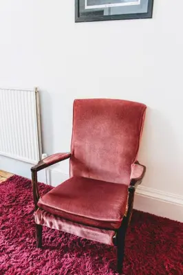 a red chair sitting on top of a red rug at Traditional Apartment oer the Meadows in Edinburgh