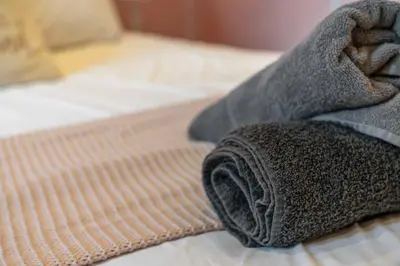 a towel is laying on a bed at Unique Victorian Home in Glasgow in Glasgow