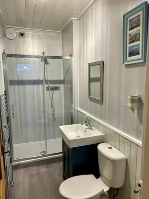 a bathroom with a shower and a toilet and a sink at Underneath the Arches in Penicuik