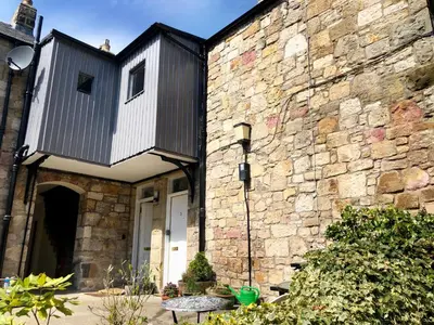 a building with a balcony on the side of it at Underneath the Arches in Penicuik