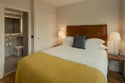 a bedroom with a large bed and a bathroom at PREMIER SUITES PLUS Glasgow Bath Street in Glasgow