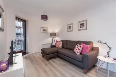 a living room with a couch and a tv at Glasgow City Flats in Glasgow