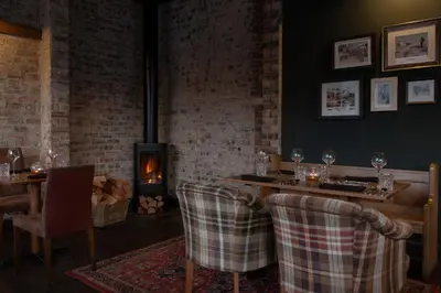 a restaurant with a table and chairs and a fireplace at The Glencoe Inn in Glencoe