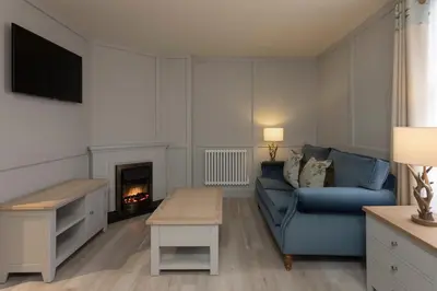 a living room with a blue couch and a fireplace at The Glencoe Inn in Glencoe