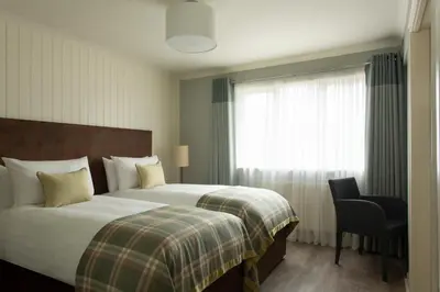 a hotel room with a bed and a window at The Glencoe Inn in Glencoe