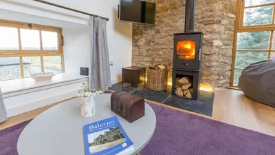 a living room with a wood burning stove at Hayloft Edinburgh in Edinburgh