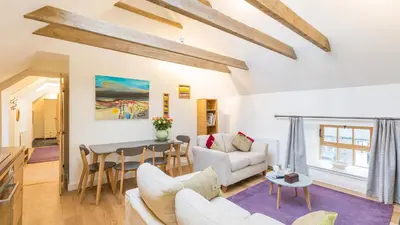 a living room with a couch and a table at Hayloft Edinburgh in Edinburgh