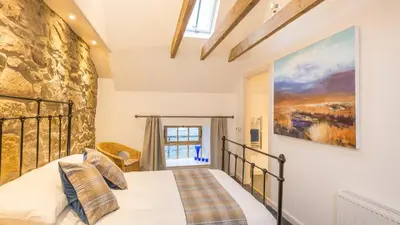 a bedroom with a bed and a stone wall at Hayloft Edinburgh in Edinburgh