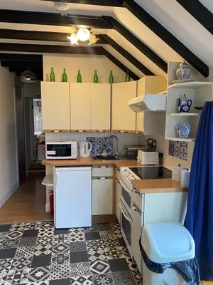 a kitchen with white cabinets and green vases at The Craighlaw Hideaway A Peaceful Village Escape 2 Bedroom Apartment with Garden in Kirkcowan