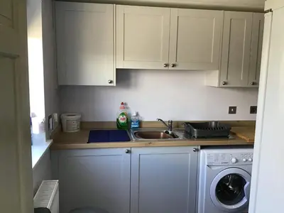 a kitchen with a sink and a washing machine at 3 Knocknaha Cottage in Campbeltown