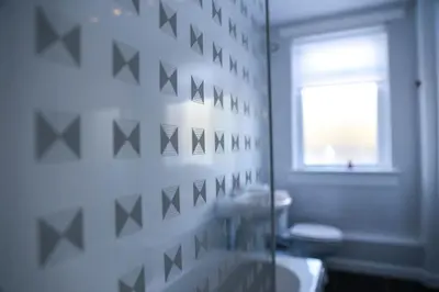 a bathroom with a toilet and a sink and a window at Meadowburn View in Wishaw