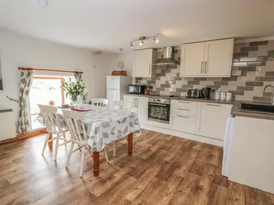 a kitchen and dining room with a table and chairs at The Dairy in Newton Stewart