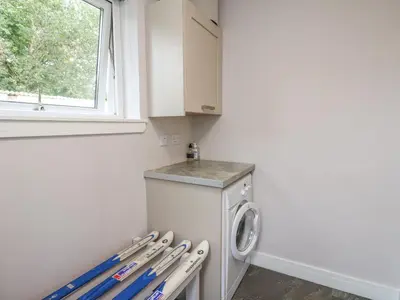 a laundry room with a washing machine and a window at Holly Cottage in Glencoe