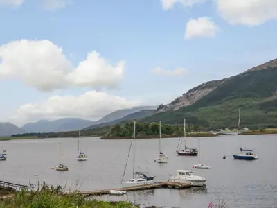 a group of boats docked in a body of water at Holly Cottage in Glencoe