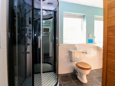 a bathroom with a toilet and a glass shower at Starfish Cottage in Craignure
