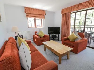 a living room with orange couches and a coffee table at Brunston Castle Lodge in Girvan
