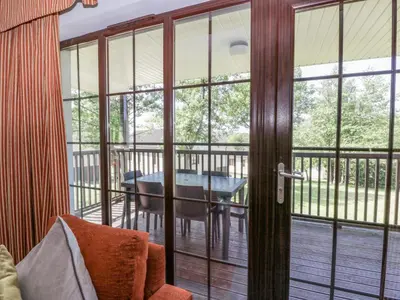 a screened in porch with a glass door and a table at Brunston Castle Lodge in Girvan