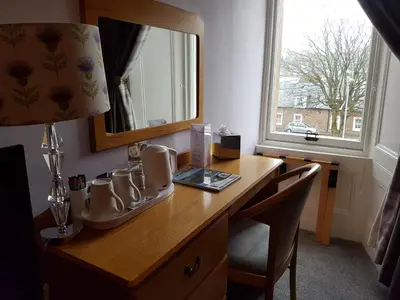 a desk with a mirror and a lamp on it at Ardshiel Hotel in Campbeltown