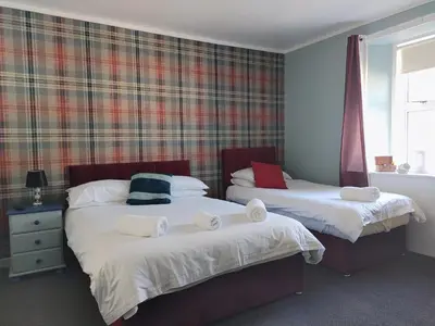 a bedroom with two beds with towels on them at The Bridge Inn in Tillicoultry