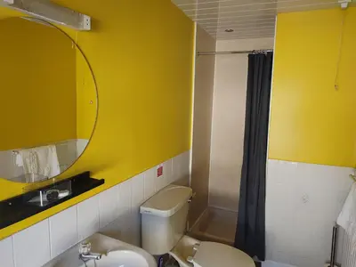a yellow bathroom with a toilet and a sink at The Bridge Inn in Tillicoultry