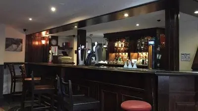 a bar in a restaurant with a counter and chairs at The Bridge Inn in Tillicoultry