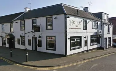 a white building on the corner of a street at The Bridge Inn in Tillicoultry