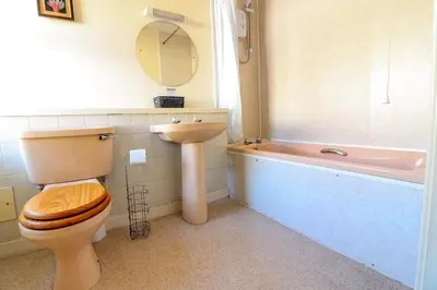 a bathroom with a toilet and a sink and a bath tub at The Bridge Inn in Tillicoultry