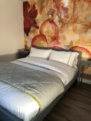 a bedroom with a bed with a painting on the wall at Finlaystone Family Barn in Port Glasgow