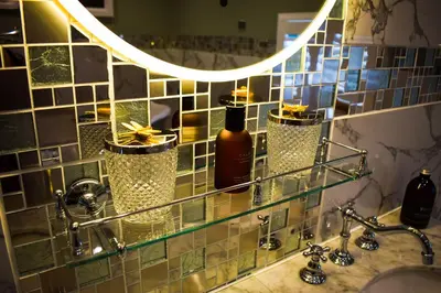 a bathroom with a sink with a mirror and bottles at Skyfall Glencoe at Creag ant Sionnaich Glencoe Ballachulish Highlands Near Fortwilliam in Glencoe