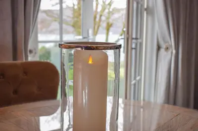 a candle in a glass vase on a table at Skyfall Glencoe at Creag ant Sionnaich Glencoe Ballachulish Highlands Near Fortwilliam in Glencoe