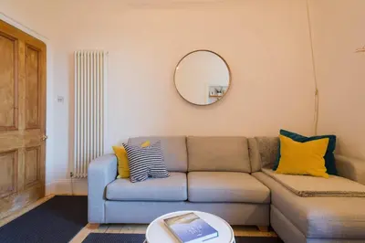 a living room with a couch and a mirror at Historic Edinburgh 1890s Home Turned Relaxing Retreat in Edinburgh