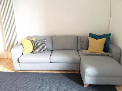 a gray couch with pillows on it in a living room at Historic Edinburgh 1890s Home Turned Relaxing Retreat in Edinburgh