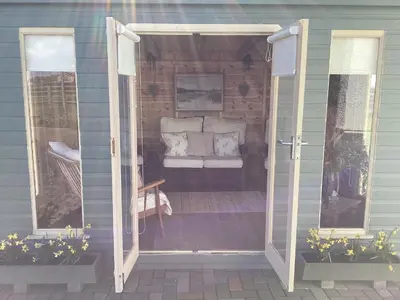 an open door to a patio with a couch outside at Auchenlea lodges in Glasgow