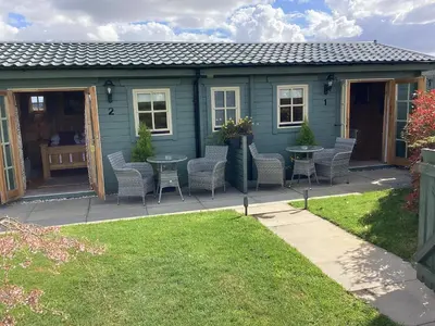 a house with a patio with chairs and a table at Auchenlea lodges in Glasgow